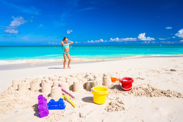 Fototapeta na wymiar Little girl playing with beach toys during tropical vacation