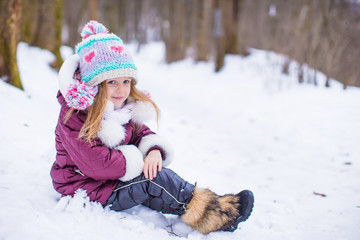 Adorable little happy girl have fun in winter snowy day outdoor