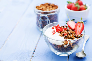 fresh breakfast of granola, yogurt, nuts, goji berries and straw