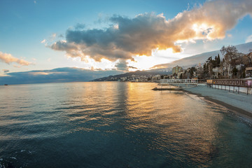 Beautiful sunset over the sea with mountain city, Yalta