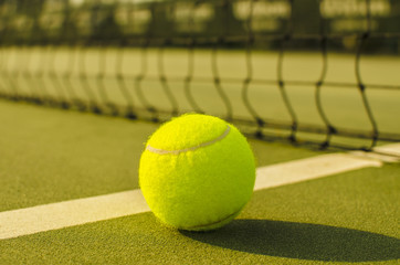 Tennis Ball on the Court with the Net in the background