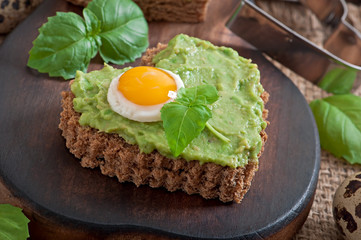 Sandwich with avocado paste and egg in the shape of heart
