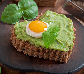 Sandwich with avocado paste and egg in the shape of heart