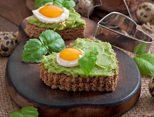 Sandwich with avocado paste and egg in the shape of heart