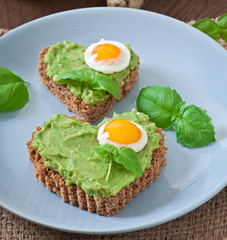 Sandwich with avocado paste and egg in the shape of heart