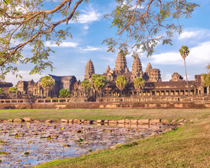Angkor Wat temple reflecting in lake with flowers