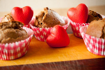 muffins with hearts on wooden desk