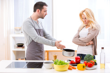 Young attractive couple having an argue while cooking