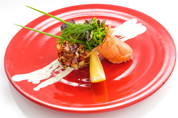 Smoked salmon with salad on red plate