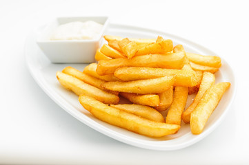 Fried potatoes on white plate with sauce