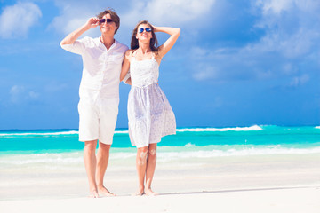 young happy couple in white at tropical beach. honeymoon