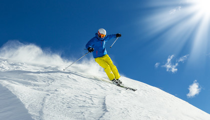 Naklejka na ściany i meble Male skier on downhill freeride with sun and mountain view