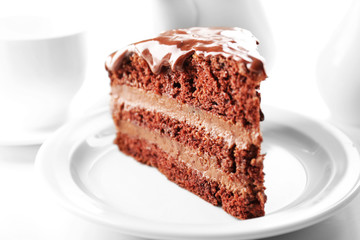 Delicious chocolate cake on plate on table on light background