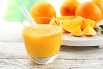 Glass of orange juice with straw and slices