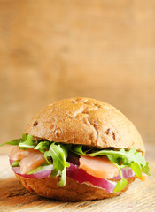 Sandwich with salmon on wooden background