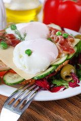Fototapeta na wymiar Sandwich with poached eggs, bacon and vegetables