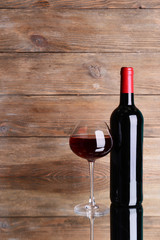 Red wine on table on wooden background