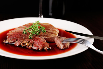 Grilled steak in wine sauce with bottle of wine