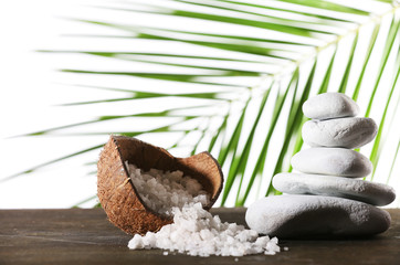 Still life of spa stones and coconut shell of sea salt