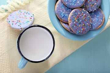 Plate of glazed cookies and mug of milk