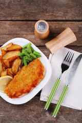 Breaded fried fish fillet and potatoes with asparagus and lemon
