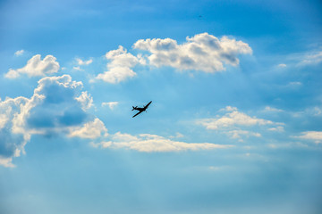 Spitfire in flight on blue cloudy sky over Bratislava - obrazy, fototapety, plakaty