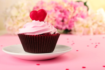 Delicious Valentine Day cupcake on pink background