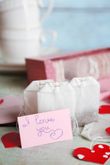 Heart shaped teabag tags and box on wooden background