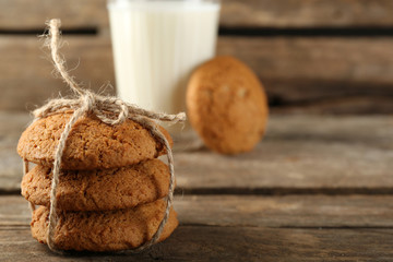 Fototapeta na wymiar Tasty cookies and glass of milk on rustic wooden background