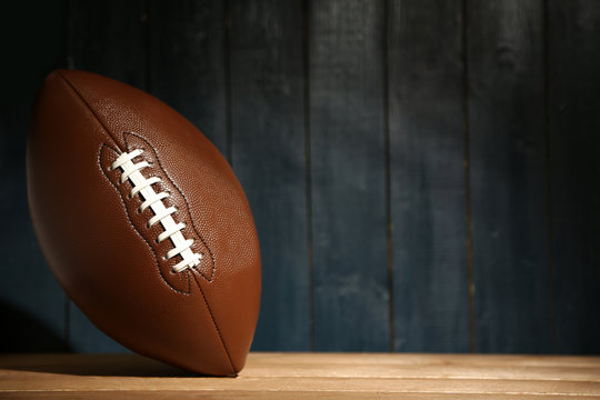 American football on wooden table, close up