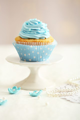 Sweet cupcake on table on light background