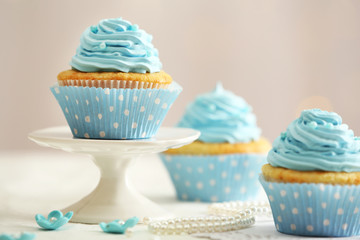 Delicious cupcakes on table on light background