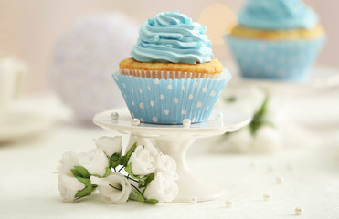 Delicious cupcakes on table on light background