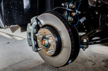 Front disc brake on car in process of new tire replacement. The