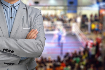 Promoter or Manager of Boxing in suit with ring on the Backgroun