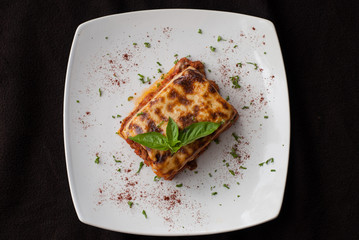Lasagna on a square white plate