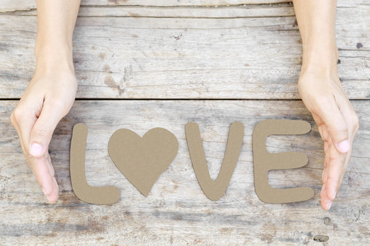word love on wood with woman hand