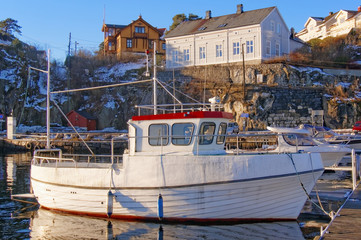 Fototapeta na wymiar White fishing boat on the harbor waterfront