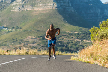 Athletic, black male running along a road