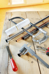 Metalwork tools lie on a wooden table in the room