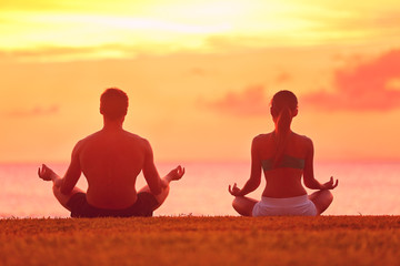 Meditation yoga couple meditating at beach sunset