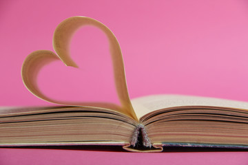 book of love with a heart on a pink background
