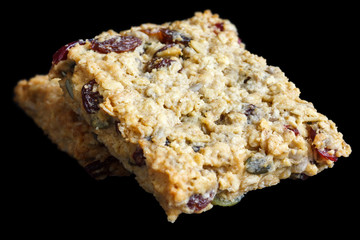 Homemade luxury fruit muesli bar. On black.