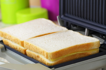 Toast with cheese and ham in toaster, closeup