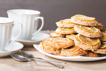 cups of tea with almond biscuits with lemon