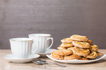 cups of tea with almond biscuits with lemon