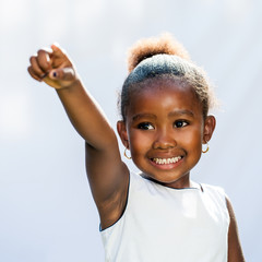 Small African girl pointing with finger into distance.
