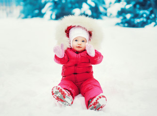 Fototapeta na wymiar Sweet baby sitting on the snow in winter day
