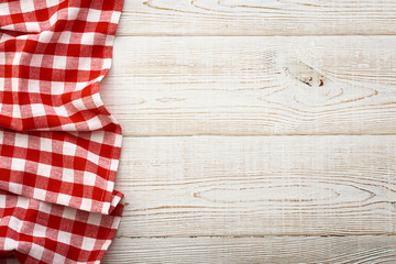 Top view of checkered tablecloth on white wooden table.