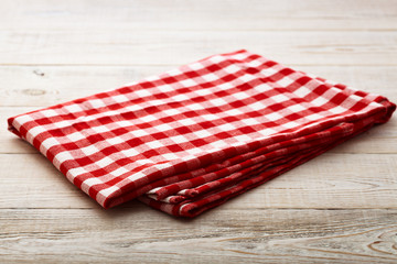 Top view of checkered tablecloth on white wooden table.